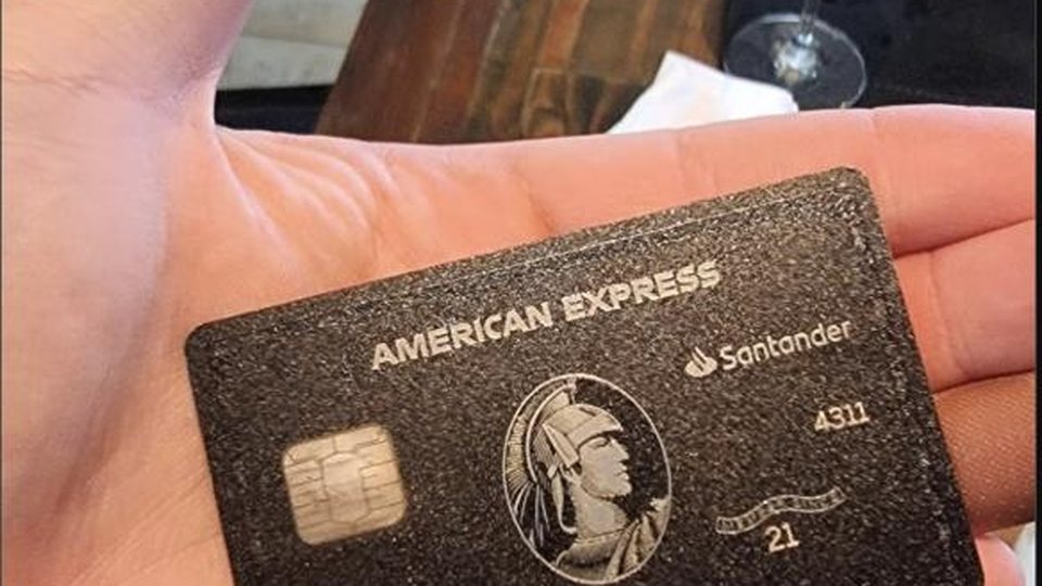 A black American Express Centurion card, held in the palm of a hand