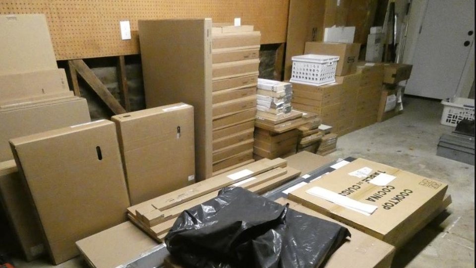 Flat-pack IKEA kitchen boxes stacked in a garage